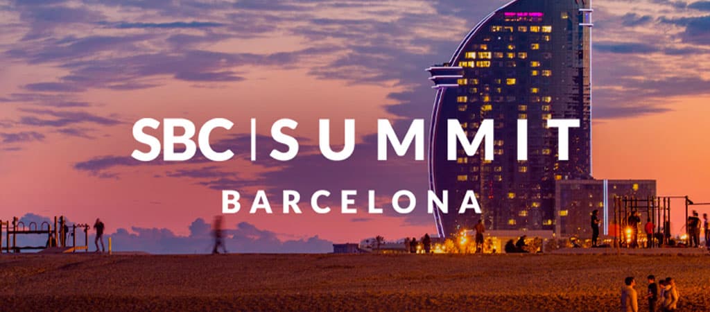 SBC Summit Barcelona, tengerpart naplementében, ikonikus W Barcelona hotel, emberek a parton, szerencsejáték konferencia 